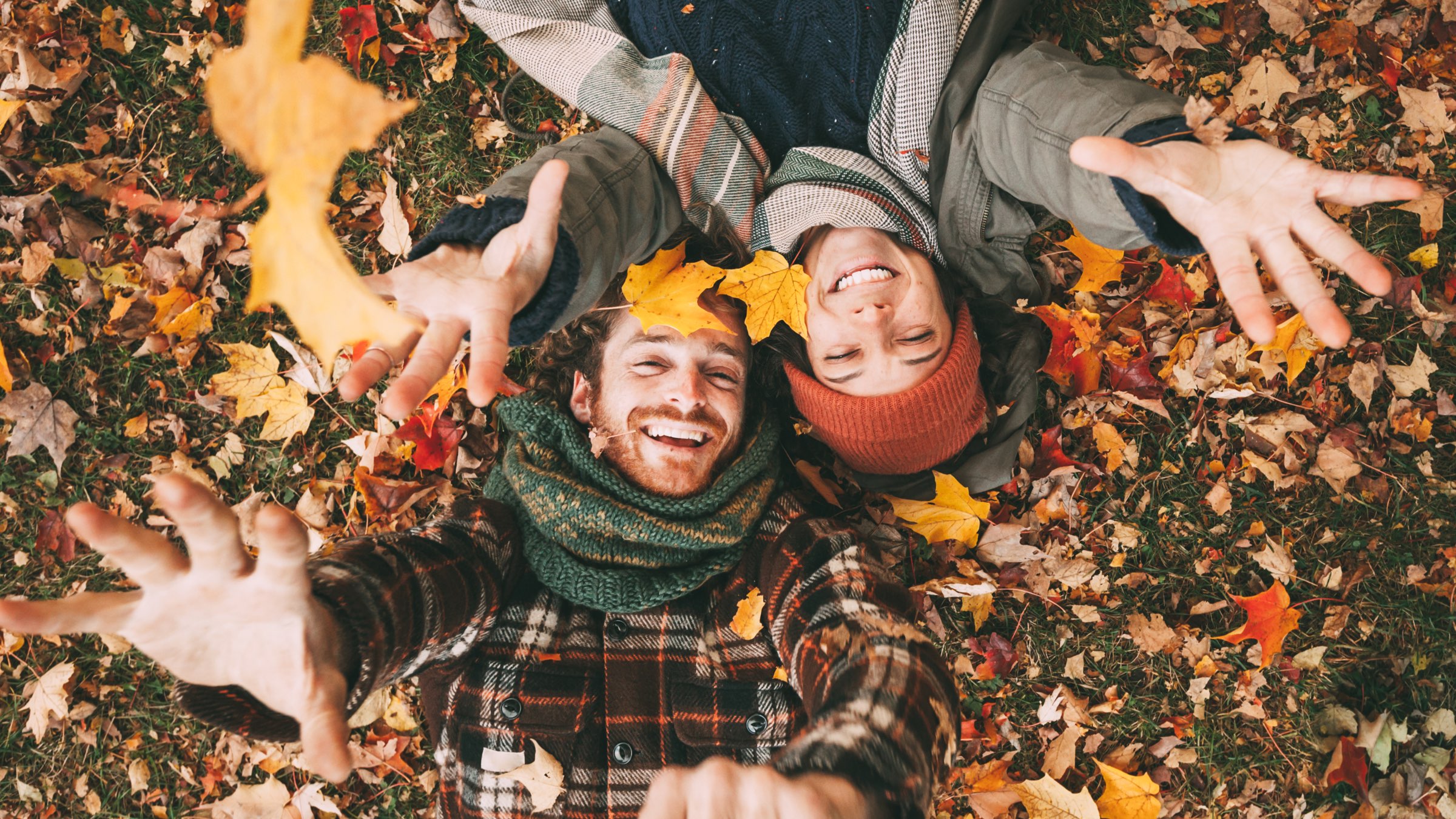 Couple laying in fall leaves