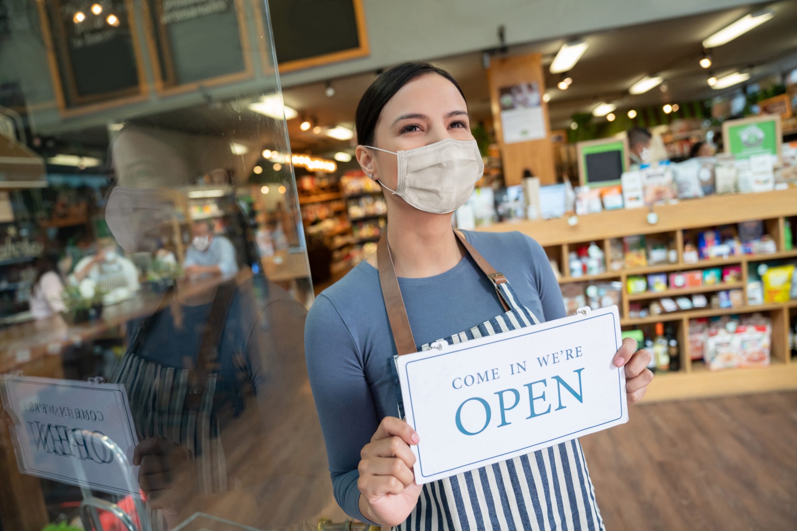 Femme avec une affiche «OUVERT»