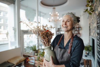 Propriétaire de café tenant un vase de fleurs