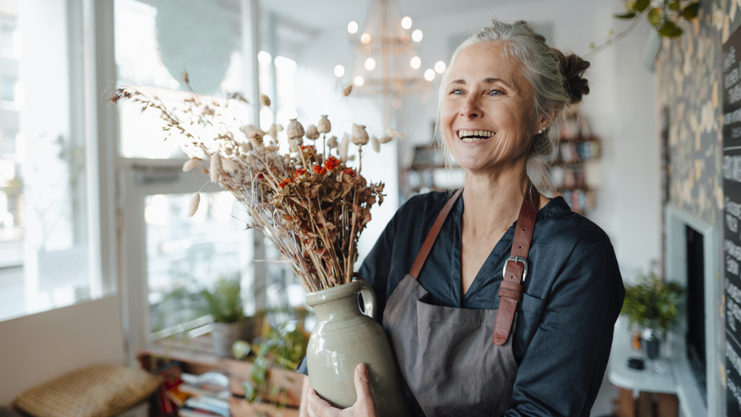 Café owner holding a flower vase