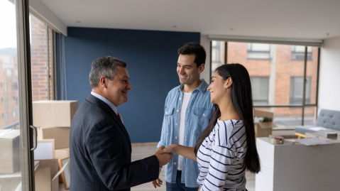 Couple shaking hands with man in a suit