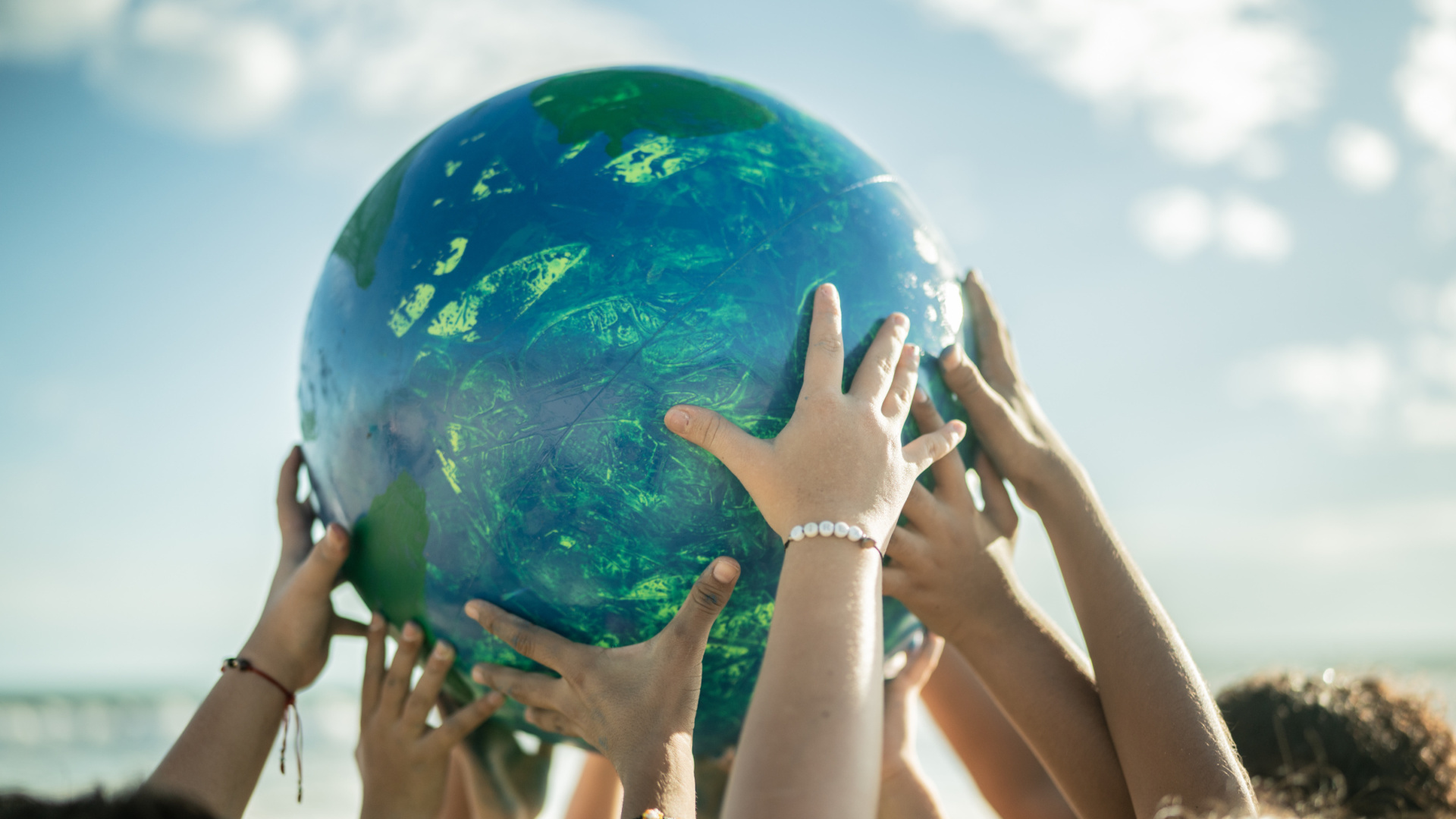 Close-up of children holding a planet at the beach