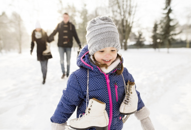 Enfant patinant avec ses parents