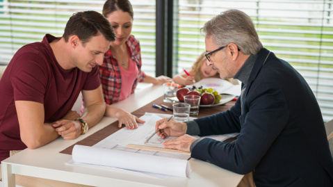 Couple examinant des plans avec un expert