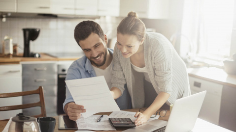 Smiling couple looking at bills