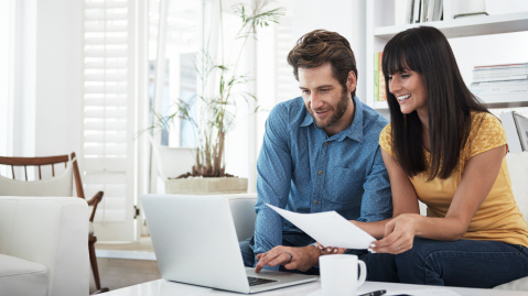 Couple using laptop at home