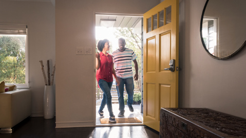 Couple walking through their front door