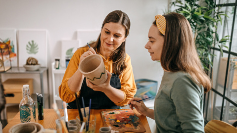 People painting pottery in a studio