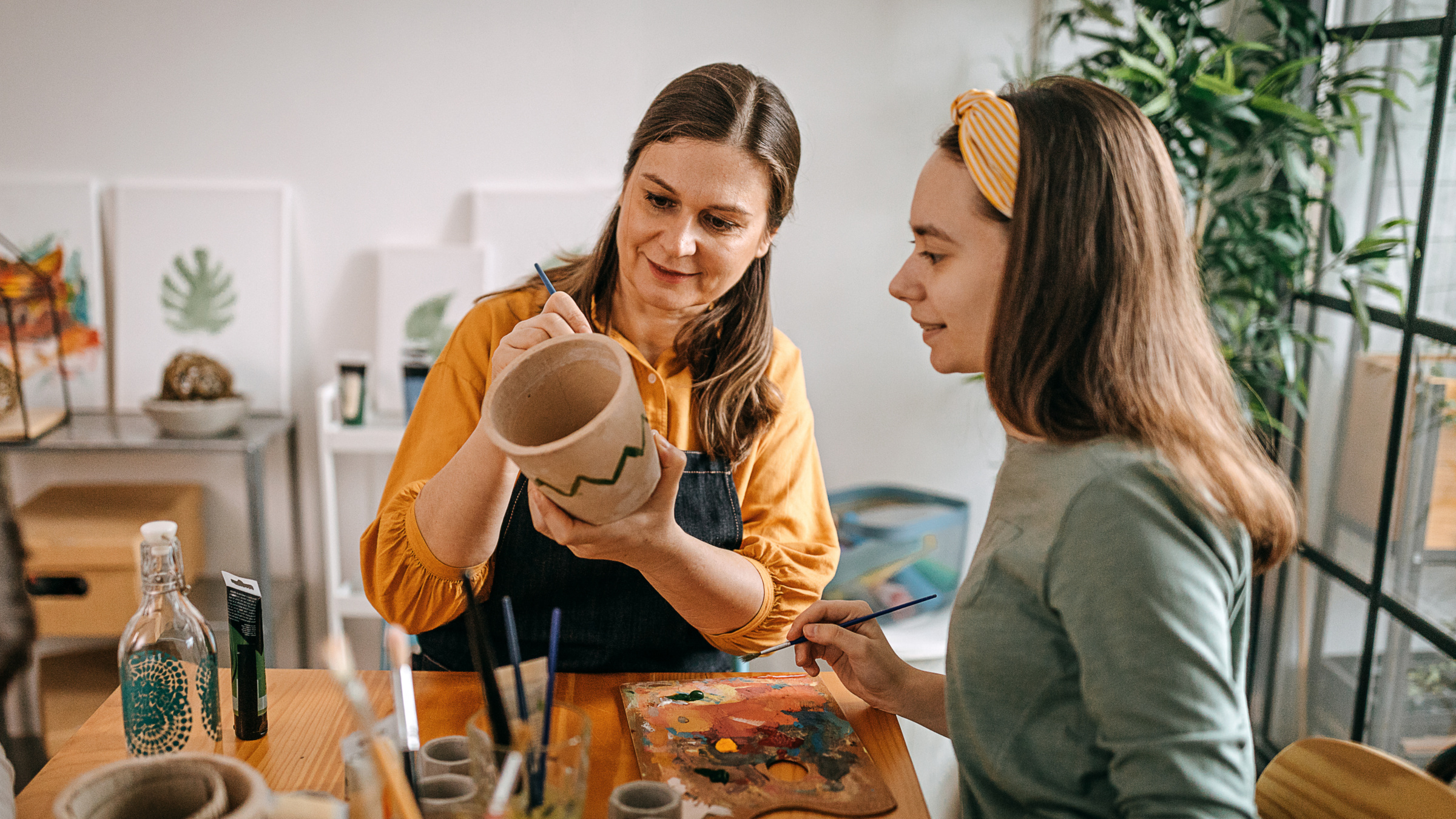 Femmes peignant une poterie dans un atelier